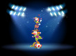 Three clowns performing on the stage with spotlights