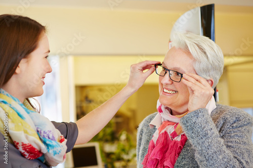 Photo: Optician advising senior woman buying glasses Optician advising senior woman buying glasses