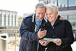 Photo: Senior couple with city guide app Senior couple with city guide app