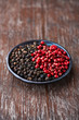 Black and pink peppercorns on a small plate