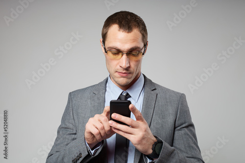 Photo: Young business man using a mobile phone Young business man using a mobile phone