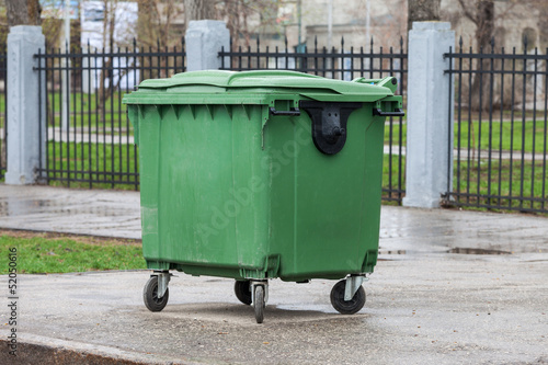 Photo: Green recycling container on the street of city Green recycling container on the street of city