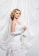 Young and beautiful bride standing with the flower bouquet over