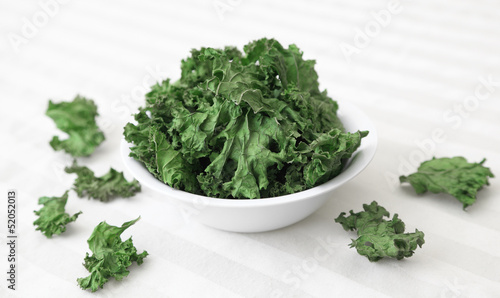 Photo: Kale Chips - A bowl of home-made kale chips sitting on a table. Kale Chips - A bowl of home-made kale chips sitting on a table.