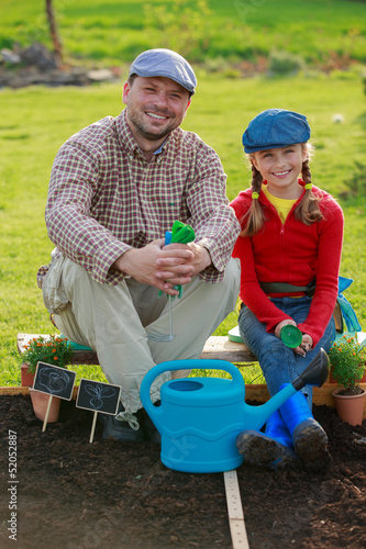 Photo: Gardening, planting - girl helping father in the garden Gardening, planting - girl helping father in the garden