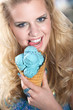 Junge Frau schleckt blaues Eis im Sommer