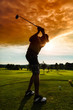 Young golf player on course doing golf swing