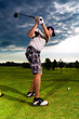 Foto: Young golf player on course doing golf swing Young golf player on course doing golf swing