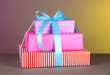 Gift box tied with a ribbon on a color background
