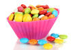 Colorful candies in cupcake case isolated on white