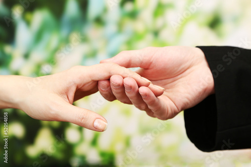 Photo: Priest holding woman hand, on green background Priest holding woman hand, on green background
