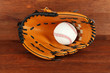 Baseball glove and ball on wooden background