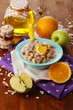 Useful oatmeal in bowl with fruit on wooden table close-up