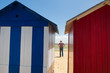 man on the beach in front of beach huts