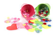 Colorful buttons strewn from buckets isolated on white