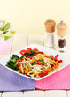 Noodles with vegetables in plate on wooden table