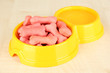 Photo: Dry dog food in bowl on wooden background Dry dog food in bowl on wooden background