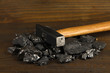 Coal with hummer on wooden background