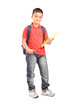 Foto: Full length portrait of a schoolboy with backpack holding a note Full length portrait of a schoolboy with backpack holding a note
