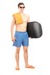 Full length portrait of a male surfer holding a surfboard and lo