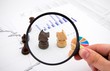 Business concept with magnifier and chess pieces on colorful bac
