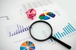 Photo: Magnifier on business background. Use for company strategic beha Magnifier on business background. Use for company strategic beha