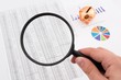 Photo: Magnifier on business background. Use for company strategic beha Magnifier on business background. Use for company strategic beha