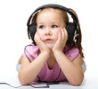 Cute little girl enjoying music using headphones