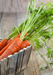 Photo: Fresh organic carrots in a wooden box. Selective focus Fresh organic carrots in a wooden box. Selective focus