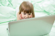 concentrated serious kid girl lying on bed with notebook