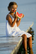 Summer  - girl eating fresh watermelon on the pier