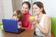 Happy women  of three generations with netbook