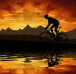 silhouette of the cyclist riding a road bike at sunset