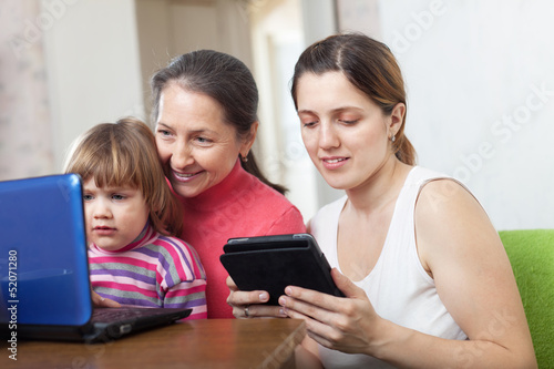 Photo: family of three generations looks devices family of three generations looks devices
