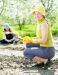women and kid sows seeds