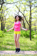 Happy young woman with skipping rope at summer park