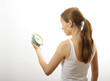 Photo: woman looking at alarm clock, on white background woman looking at alarm clock, on white background
