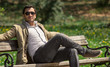 Handsome man resting on a bench in park