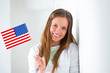 Portrait of a lovely young woman with United State's flag smilin