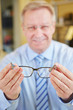 Optician holding glasses at consultation