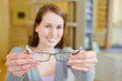 Young woman holding new glasses