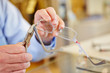 Hand of optician fixing glasses