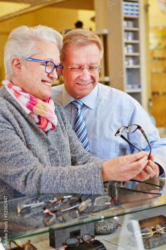 Photo: Two seniors buying glasses at optician Two seniors buying glasses at optician