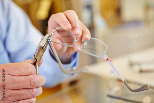 Photo: Hand of optician fixing glasses Hand of optician fixing glasses