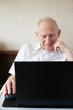 Smiling Senior Man In Front Of the Laptop