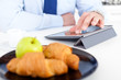 Businessman with tablet at breakfast
