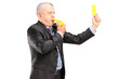A mature businessman blowing a whistle and showing a yellow card