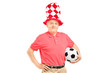A middle aged male fan with hat holding a soccer ball