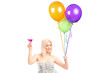 A pretty blond female holding balloons and cocktail