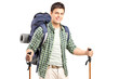 A smiling hiker with backpack and hiking poles posing